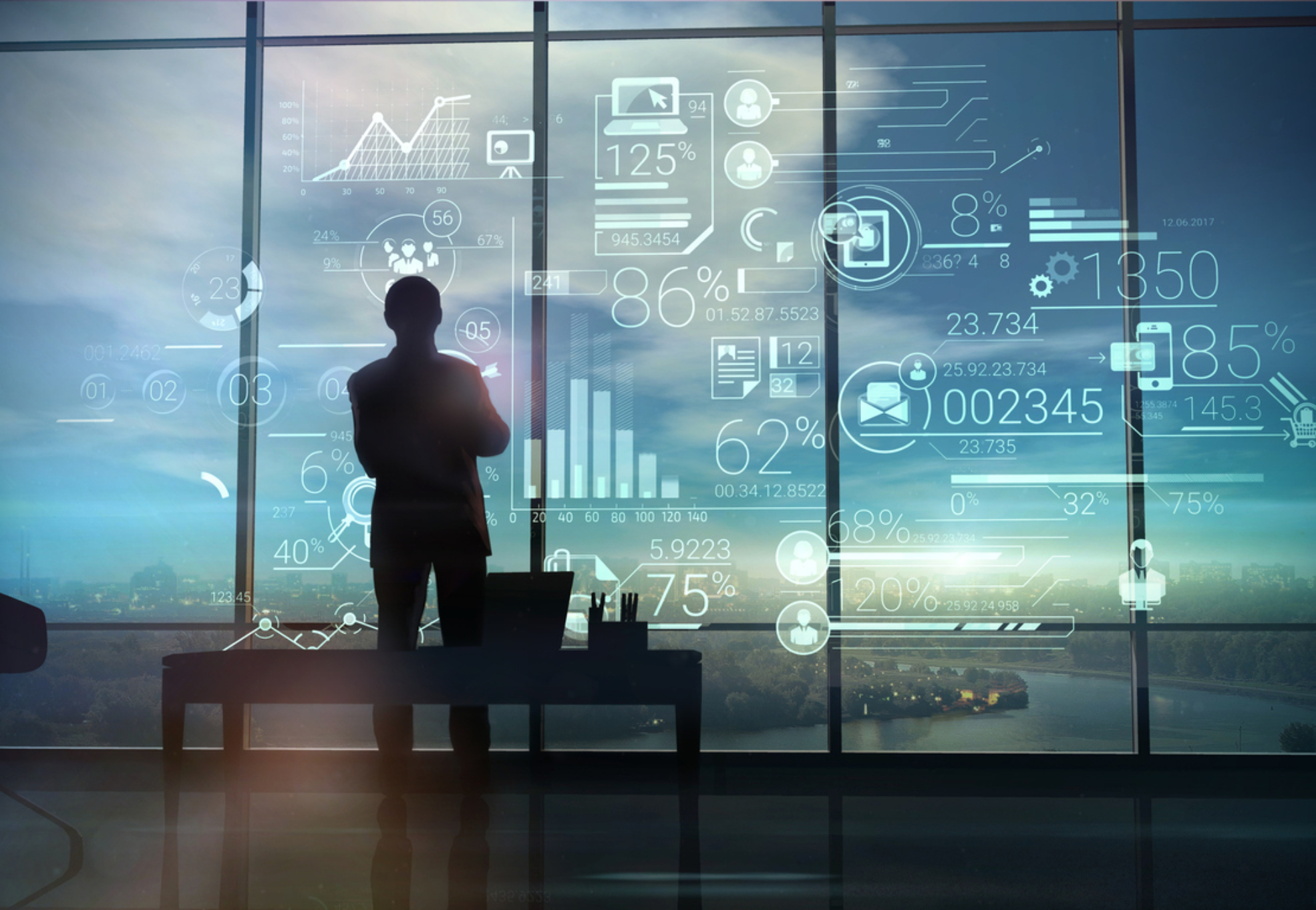 A silhouette of a man stands on the background of large office windows and views a hologram of corporate infographic with work data.